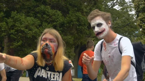 Couple with painted faces slowly moving forward on a background of a busy street Stock Footage 68209377