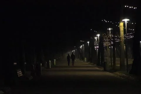 Couple on a park alley night time Stock Photos