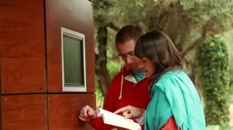 Couple in the park typing on touchscreen, steadicam shot 스톡 동영상 10842250