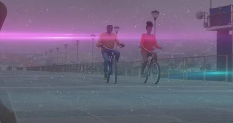 Couple pedaling toward camera on waterfront, pink flare and stars overlaying Stock Footage 333904850