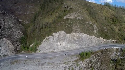 Couple of people launch the drone with the camera among mountains on the road in Stock Footage 71470172