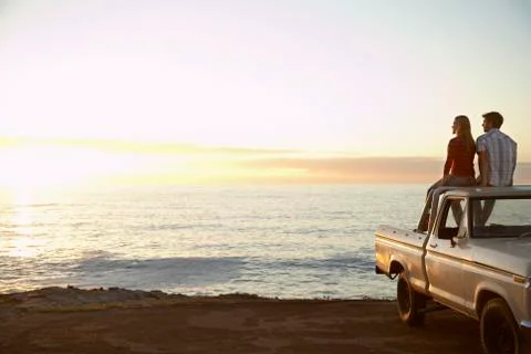 Couple On Pick-Up Truck Parked In Front Of Ocean Stock Photos