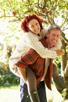 Couple picking apples off tree Stock Photos