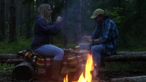 A couple on a picnic night in the woods in the fall peeling mushrooms by the fir Vídeos de archivo 283671763