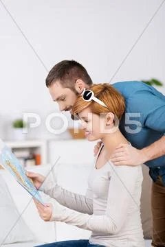 Couple planning while looking at map in house Stock Photos