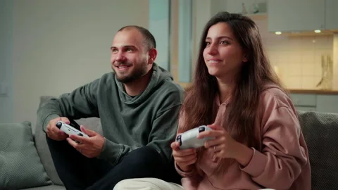 Couple play in game using controllers wireless gaympad or joystick. Man winner Stock-Footage 160649146