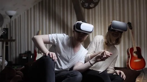 Couple Play a Roller Coaster in Virtual Reality Glasses in the Game Room Stock Footage 74695849
