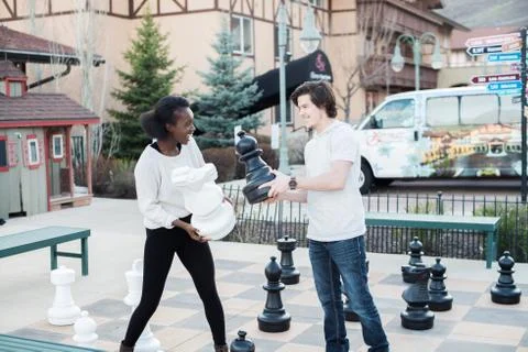 Couple Playfully Interacts During Oversized Chess Game Stock Photos