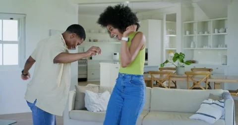 Couple playfully tapping speaker and dancing near sofa with tech animated music Stock Footage 341944458