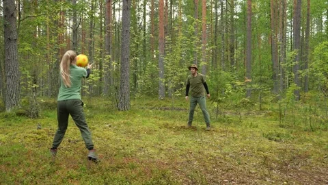 A couple is playing ball, spending time actively during a nature Video stock 318716360