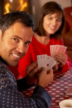 Couple Playing Cards By Cosy Log Fire Stock Photos