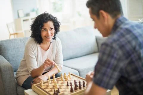 Couple playing chess in living room Stock Photos
