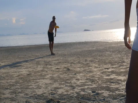 Couple Playing Frisbee on the Beach 스톡 동영상 77373587