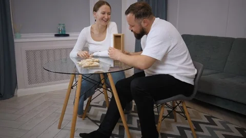 Couple playing jenga, having fun at home Stock Footage 320499976