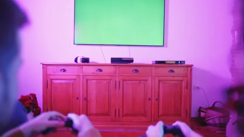 Couple Playing Video Games Console Living Room Colorful Green Screen TV Video stock 195289743