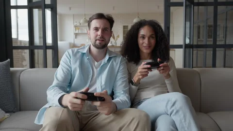 Couple Playing Video Games On Couch, Focused, Competitive In Cozy Home Setting Stock Footage 306699443