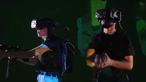 The couple is playing a virtual reality simulation in a dark studio with lights. Stock Footage 317300371