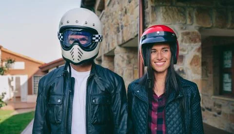 Couple posing with motorcycle helmets Stock Photos