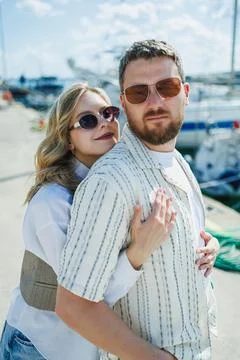 Couple posing together at a marina while wearing sunglasses on a sunny day Fotos Stock