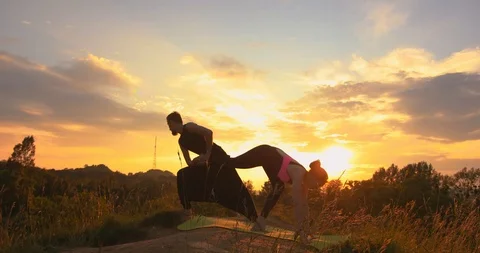 Couple practicing acro yoga outside. Acro yoga concept. Pair yoga. Yoga Stock Footage 120344450