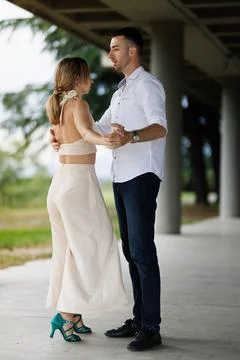 Couple practicing partner dance under a covered pavilion, man and woman Stock Photos