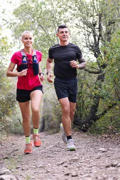 Couple practicing trail running in the forest Stock Photos