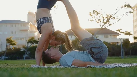Couple practising acro yoga at sunset Stock Footage 76521394
