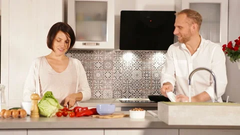 Couple preparing breakfast in kitchen smiling and talking cheerfully Stock-Footage 140821688