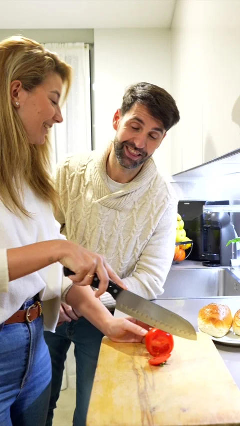 Couple preparing dinner together, slicing tomatoes Stock Footage 303554656