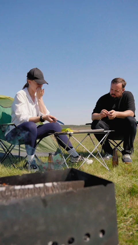 Couple preparing food together during a camping picnic in nature Видео 344603786