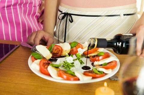 Couple preparing mozzarella with tomatoes, mid section Stock Photos