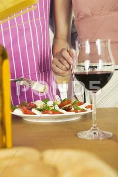 Couple preparing mozzarella with tomatoes, mid section Stock Photos