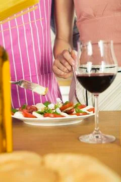 Couple preparing mozzarella with tomatoes, mid section Stock Photos