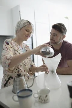 Couple preparing pour over coffee in morning kitchen Fotos Stock