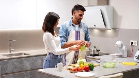 Couple preparing salad together in modern kitchen Stock Footage 302927931