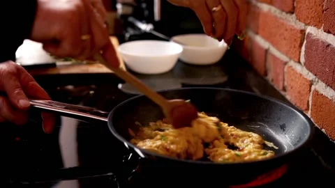 Couple preparing scrambled eggs in the kitchen at home, focus on hands Stock Footage 93110882