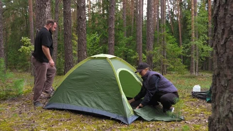 Couple preparing a tent for camping in the forest Stock Footage 327134576