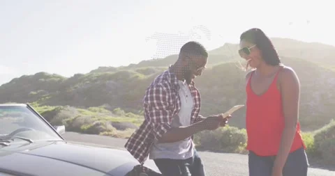Couple pulling over coastal road, reading folded map, planning travel, woman Stock Footage 332281937