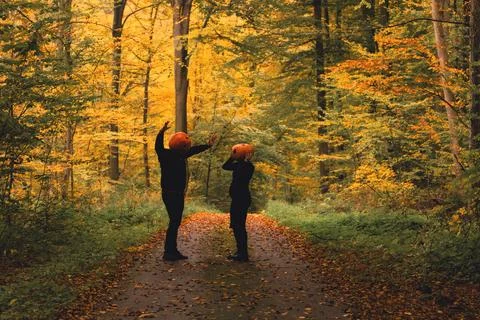 Couple with pumpkin head in fall forest Stock Photos