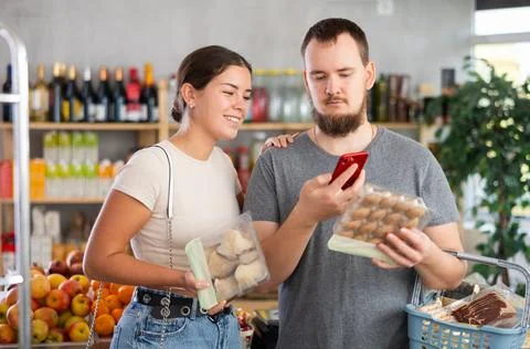 Couple purchaser scanning QR code or barcode of mushrooms in supermarket Stock Photos