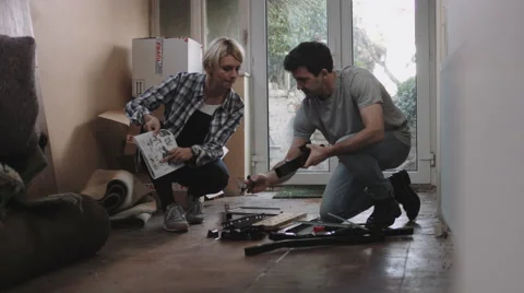 Couple putting together flatpack shelving Stock Footage 61784787