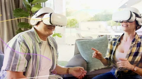 Couple putting on white VR headsets, gesturing with technology demo via colored Stock Footage 332704943