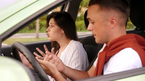 A couple quarrels sitting in the car, a guy is driving and yelling at his wife. Stock Footage 213984707