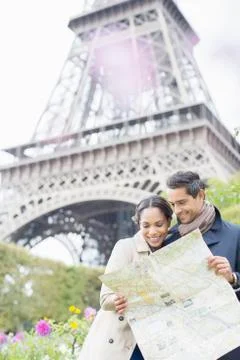 Couple reading map in front of Eiffel Tower, Paris, France Stock Photos