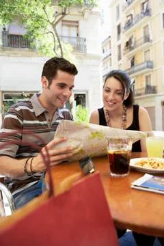 Couple Reading Map At Sidewalk Cafe Fotos Stock