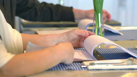 Couple reading menu in the restaurant in 4k slow motion 60fps Stock Footage 93601780
