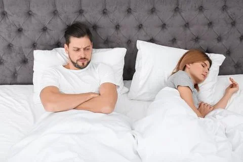 Couple with relationship problems in bed at home Stock Photos