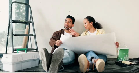 Couple, relax and talk at new house with blueprint, layout and information for Stock Footage 337038480