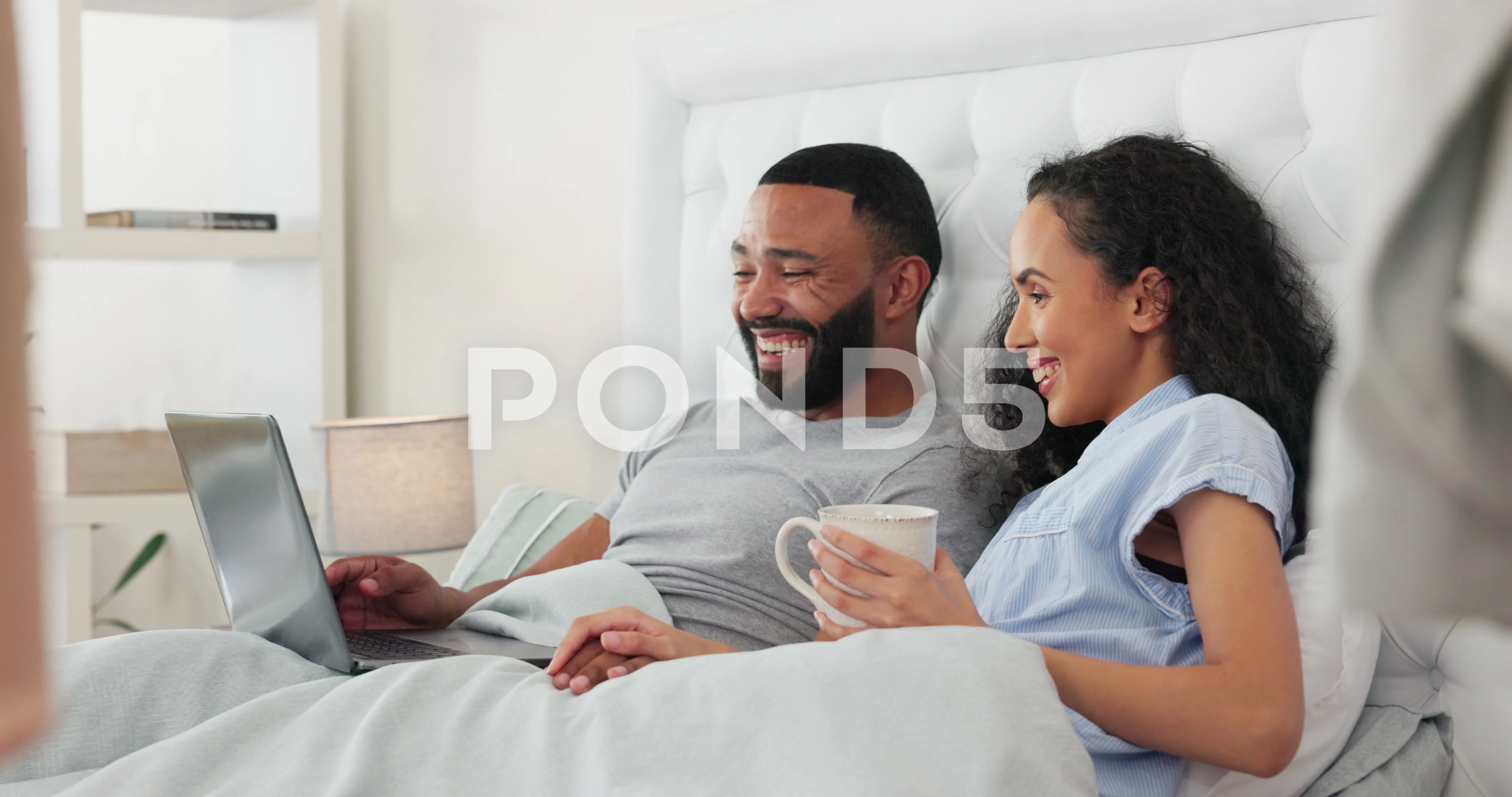 Couple relax in bed, watch movie on laptop together and happy with streaming