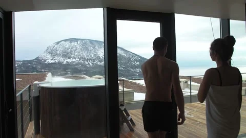 Couple relax in the hot pool in the winter outdoors with sea and mountain views Stock Footage 149352281